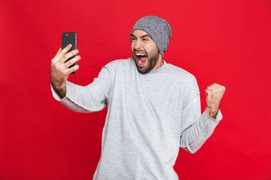 Heyecanlı adamın 30'lu sakal ve bıyık smartph holding ile görüntü