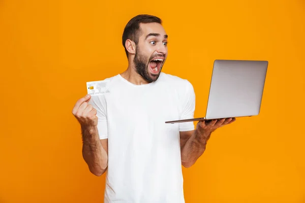 Portret van extatische man 30s in wit t-shirt bedrijf zilveren ronde — Stockfoto