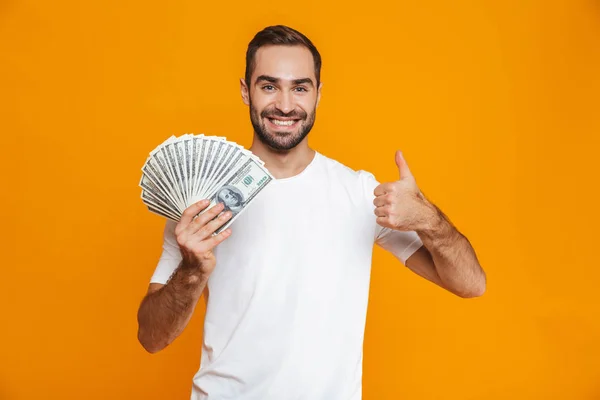 Photo of optimistic man 30s in casual wear holding bunch of mone — Stock Photo, Image