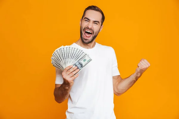Emocionální muž 30s v oblečení drží balík peněz — Stock fotografie