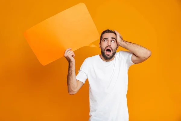 Foto del hombre sorprendido de 30 años en ropa casual sosteniendo un cartel de copyspace — Foto de Stock