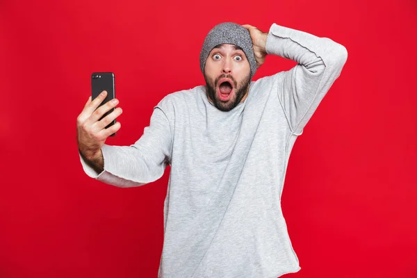 Εικόνα του αρπάζοντας κεφάλι Καυκάσιος άνδρα 30s και της εκμετάλλευσης του smartphone — Φωτογραφία Αρχείου