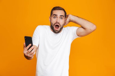 Beyaz fotoğrafı 30'lu yaşlarda rahat kıyafet smartphone tutan adam, olduğunu