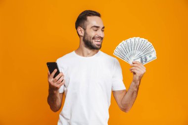 Fotoğraf gülümseyen adam rahat kıyafet holding cep telefonu ve f 30'lu yaşlarda