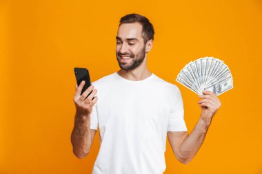 Fotoğraf iyimser adamın 30'lu rahat kıyafet cep telefonu tutan bir