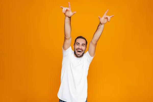 Image of excited guy 30s in t-shirt rejoicing and smiling while — Stock Photo, Image