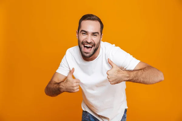 Bild des gutaussehenden Typen um die 30 im T-Shirt jubelt und Daumen zeigt — Stockfoto