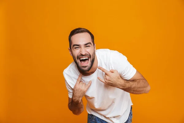 Imagen del chico feliz de 30 años en camiseta regocijándose y mostrando sig rock — Foto de Stock