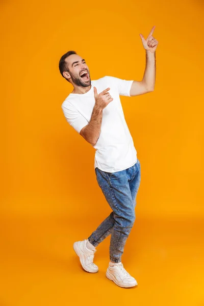 Imagem de comprimento total do cara positivo 30s em t-shirt e jeans point — Fotografia de Stock