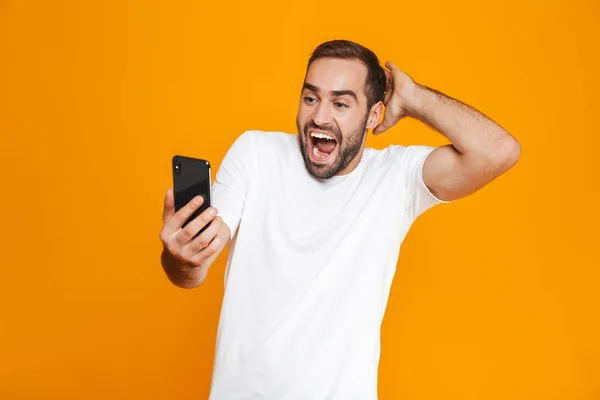 Foto de hombre optimista 30s en ropa casual sonriendo y sosteniendo s — Foto de Stock