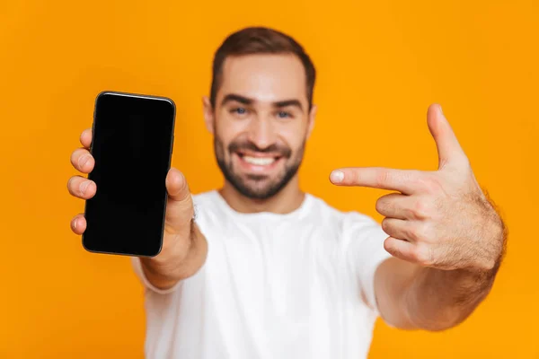 Foto de homem bem parecido 30 anos em casual desgaste sorrindo e segurando — Fotografia de Stock