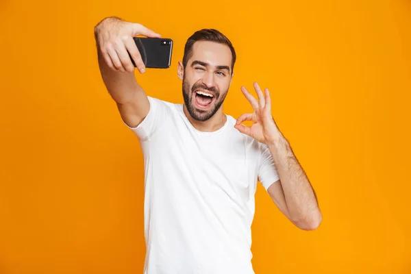 Foto de chico emocional 30s en ropa casual riendo y tomando se — Foto de Stock