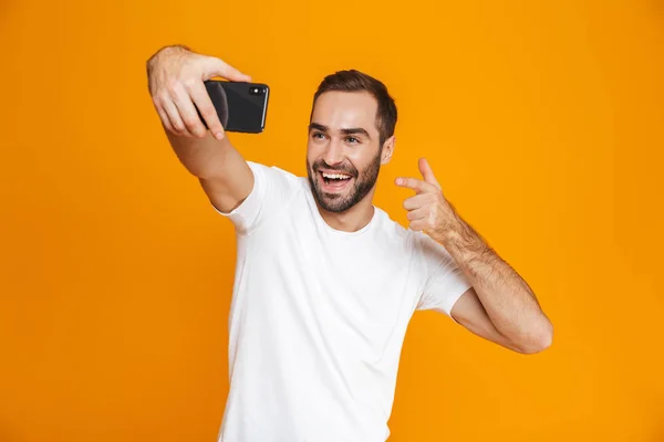 Foto de chico complacido 30s en ropa casual riendo y tomando uno mismo — Foto de Stock