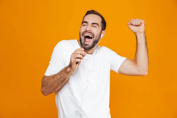 Foto de homem caucasiano de 30 anos cantando ao usar fones de ouvido e multidão — Fotografia de Stock