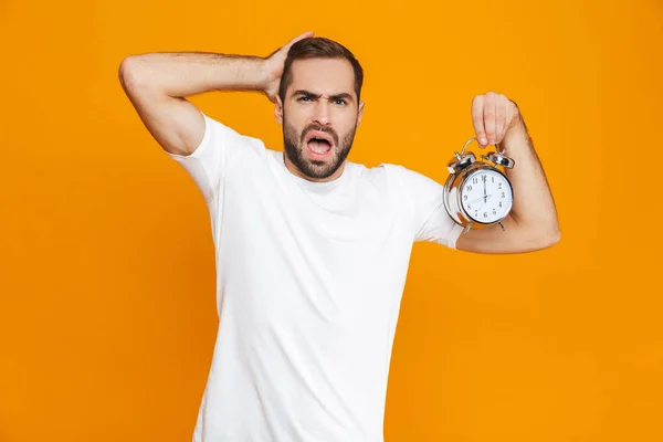 Foto de hombre tenso 30s en ropa casual celebración de reloj despertador, iso —  Fotos de Stock