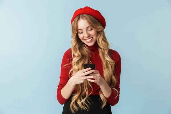 Fotó a 20-as évek gyönyörű lány visel piros beret használ smartphone — Stock Fotó
