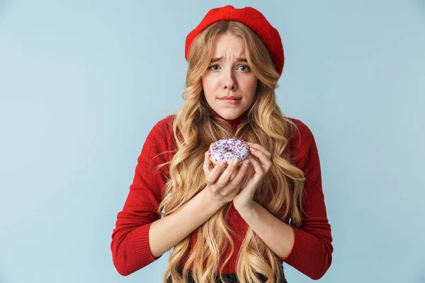 Bilden av ung blond kvinna 20s bär röd basker äta donut — Stockfoto