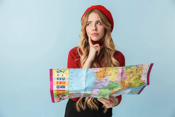 Imagen de una mujer rubia desconcertada de 20 años con boina roja en el mundo de la celebración — Foto de Stock