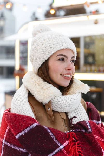 Hermosa joven bonita mujer en sombrero y bufanda caminando al aire libre en la calle del parque nevado . —  Fotos de Stock