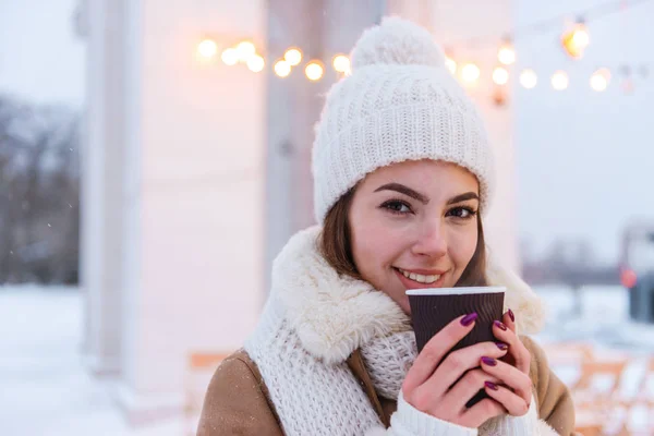 Giovane donna in cappello e sciarpa camminare all'aperto in inverno neve bere caffè . — Foto Stock