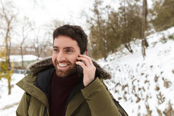 Schöner junger Mann in Winterjacke stehend — Stockfoto