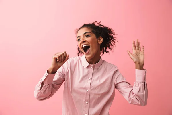 Bela jovem africana mulher posando isolado sobre rosa parede fundo gritando cantando . — Fotografia de Stock