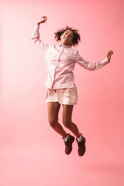 Bela jovem africana mulher posando isolado sobre rosa parede fundo saltando . — Fotografia de Stock