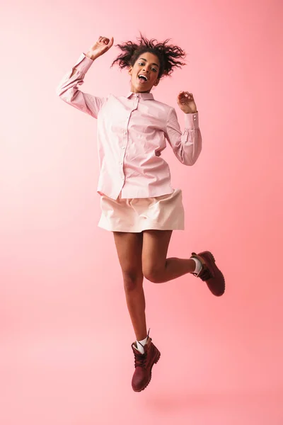 Bela jovem africana mulher posando isolado sobre rosa parede fundo saltando . — Fotografia de Stock