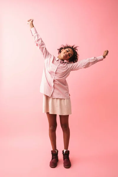 Bela jovem africana mulher posando isolado sobre rosa parede fundo alongamento . — Fotografia de Stock