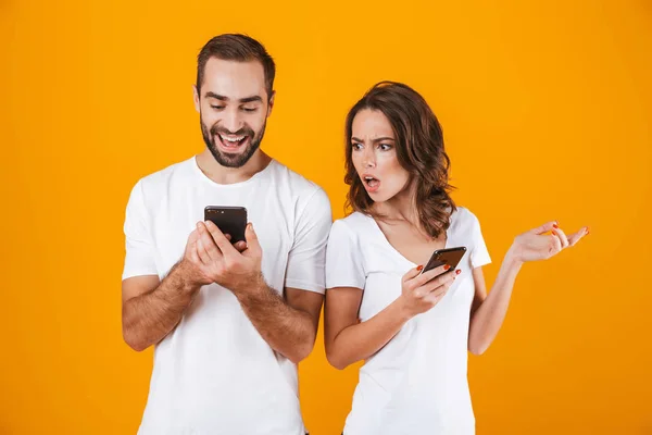 Foto de hombre y mujer curiosos sosteniendo y mirando el teléfono celular — Foto de Stock