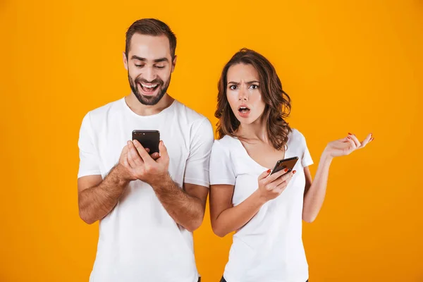 Foto av ung man och kvinna holding och kikar på mobiltelefon, — Stockfoto