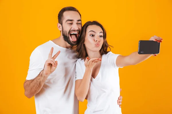 Portrait of two excited people man and woman taking selfie photo