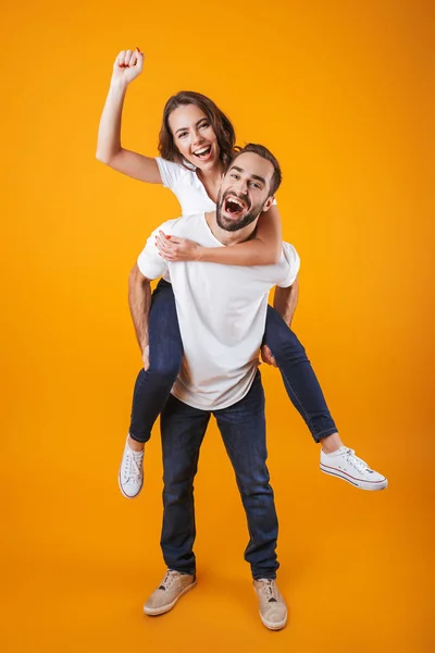 Εικόνα πλήρους μήκους του ζευγάρι έχει τη διασκέδαση ενώ piggybacking στο άτομο — Φωτογραφία Αρχείου