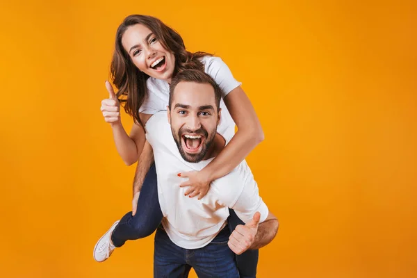 Εικόνα του χαμογελώντας ζευγάρι έχει τη διασκέδαση ενώ piggybacking χαρούμενο άτομο — Φωτογραφία Αρχείου