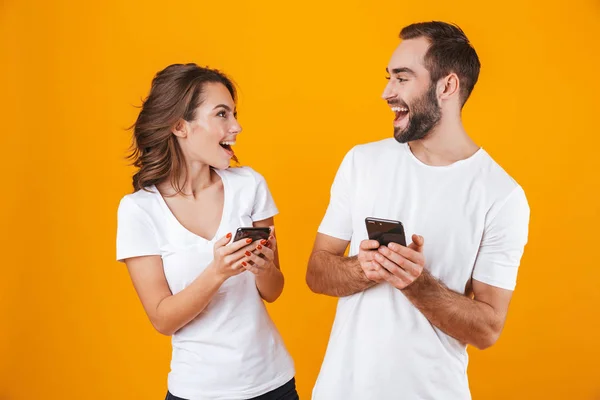 Imagen de pareja hombre y mujer sonriendo mientras ambos usan el ph móvil — Foto de Stock