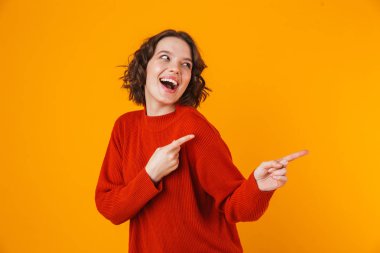 Duygusal genç güzel kadın boşaltmak gösterilen sarı duvar arka plan üzerinde izole poz.