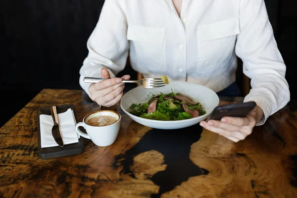 Primer plano de una mujer comiendo ensalada mientras está sentada en el café — Foto de Stock