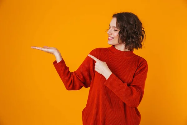 Glücklich emotionale junge hübsche Frau posiert isoliert über gelben Wand Hintergrund zeigt Kopierraum. — Stockfoto