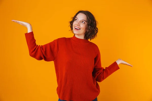 Animado feliz emocional jovem bonita mulher posando isolado sobre amarelo parede fundo mostrando copyspace . — Fotografia de Stock