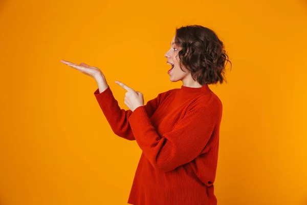 Glücklich emotionale junge hübsche Frau posiert isoliert über gelben Wand Hintergrund zeigt Kopierraum. — Stockfoto