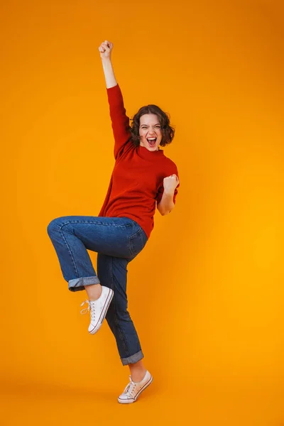 Upphetsad känslomässiga glad ung vacker kvinna poserar isolerade över gul vägg bakgrund. — Stockfoto