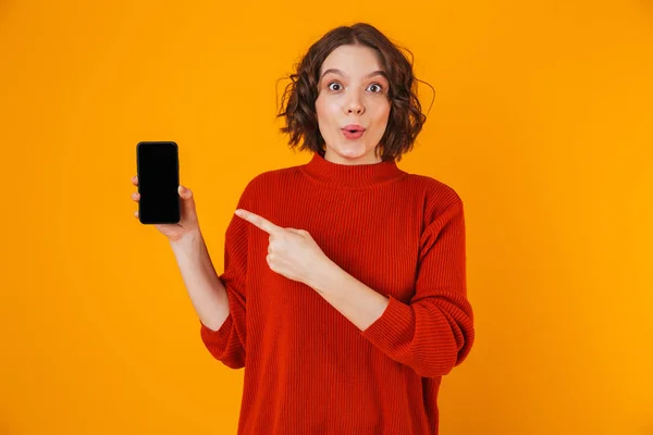 Porträt einer lockigen Frau, die ihr Smartphone in der Hand hält und demonstriert — Stockfoto