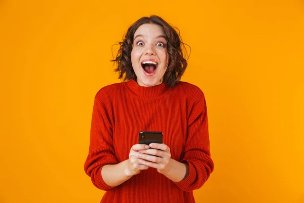 Porträt einer brünetten Frau, die ihr Handy hält und benutzt, während sie — Stockfoto