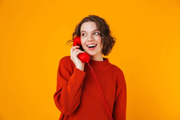 Emocional joven bonita mujer posando aislada sobre fondo amarillo de la pared hablando por teléfono . —  Fotos de Stock