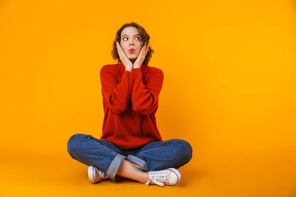 Emotional schockierte junge hübsche Frau posiert isoliert über gelbem Wandhintergrund. — Stockfoto