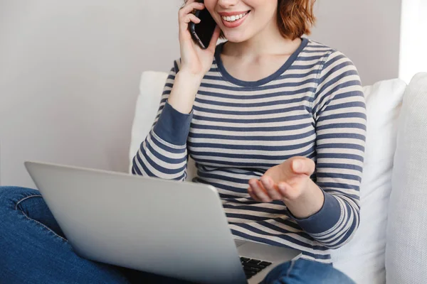 Hermosa joven sonriente relajándose en un sofá — Foto de Stock