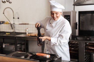 Gülümseyen kadın şef aşçı giyen üniforma pişirme