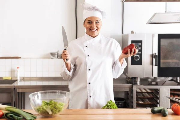 Foto de mujer caucásica chef con uniforme blanco comida de cocina —  Fotos de Stock