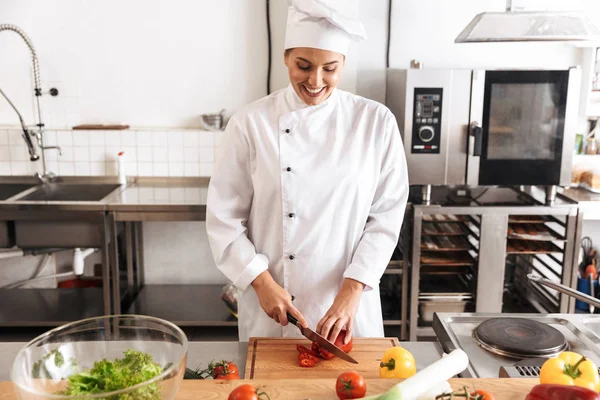 Foto de mujer chef satisfecha con comida blanca de cocina uniforme —  Fotos de Stock