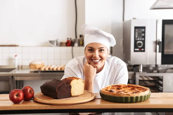 Image d'une femme chef positive portant un uniforme blanc, posant en ki — Photo